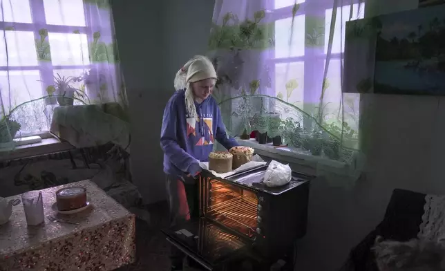 Daria Strukova takes Easter cakes off a stove in her family home in the remote mountain village of Orlovka, Georgia, Saturday, May 4, 2024. (AP Photo/Kostya Manenkov)