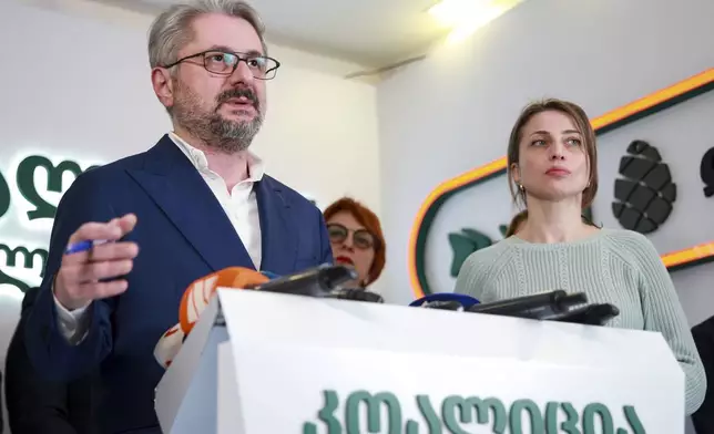 Nika Gvaramia, leader of Coalition for Changes, left, speaks to the media as and Nana Malashkhia, who leads the Coalition for Change parliament list, right, stands near, at coalition's headquarters after the parliamentary election in Tbilisi, Georgia, Sunday, Oct. 27, 2024. (AP Photo/Zurab Tsertsvadze)