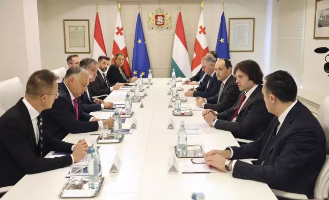 In this photo released by Georgian Prime Minister Press Office on Tuesday, Oct. 29, 2024, Georgian Prime Minister Irakli Kobakhidze, 2nd right, and Prime Minister of Hungary Viktor Orban, 2nd left, speak during their meeting in Tbilisi, Georgia. (Georgian Prime Minister Press Office via AP)