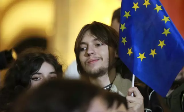 A young man holds an EU flag as he attends an opposition protest against the results of the parliamentary election in Tbilisi, Georgia, on Monday, Oct. 28, 2024. (AP Photo/Zurab Tsertsvadze)