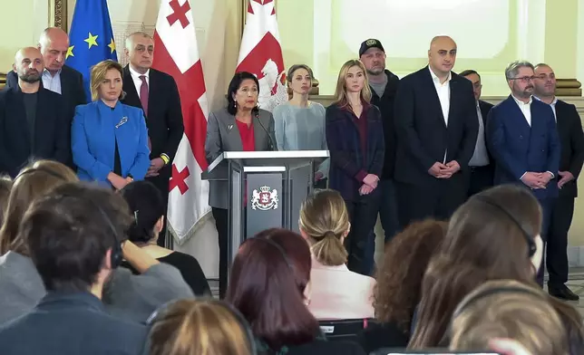 In this photo taken from video, Georgian President Salome Zourabichvili, center, surrounded by opposition leaders speaks to the media after the parliamentary election in Tbilisi, Georgia, on Sunday, Oct. 27, 2024. (AP Photo/Kostya Manenkov)