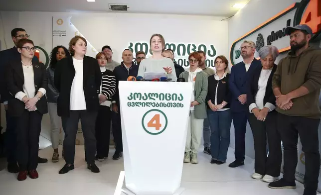 Nana Malashkhia, who leads the Coalition for Change parliament list, center, speaks to the media at coalition's headquarters after the parliamentary election in Tbilisi, Georgia, Sunday, Oct. 27, 2024. (AP Photo/Zurab Tsertsvadze)