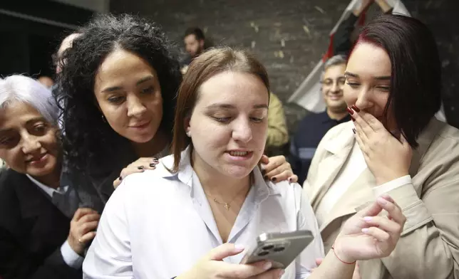 Supporters of the Coalition for Change look at the phone at coalition's headquarters after polls closing at the parliamentary election in Tbilisi, Georgia, Saturday, Oct. 26, 2024. (AP Photo/Zurab Tsertsvadze)