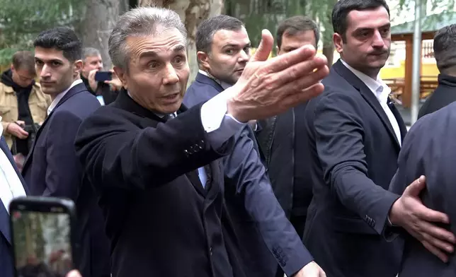 In this photo taken from video, Bidzina Ivanishvili, leader of the created by him the Georgian Dream, center, gestures as he arrives to vote at a polling station during the parliamentary election in Tbilisi, Georgia, Saturday, Oct. 26, 2024. (AP Photo/Kostya Manenkov)