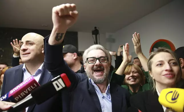 From left, Nika Melia and Nika Gvaramia, leaders of Coalition for Changes, and Nana Malashkhia, who leads the Coalition for Change parliament list, react while talking to journalists at coalition's headquarters after polls closing at the parliamentary election in Tbilisi, Georgia, Saturday, Oct. 26, 2024. (AP Photo/Zurab Tsertsvadze)