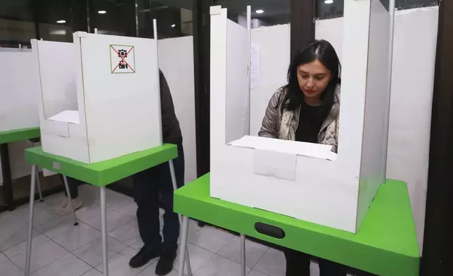 People fill their ballots at a polling station during the parliamentary election in Tbilisi, Georgia, Saturday, Oct. 26, 2024. (AP Photo/Zurab Tsertsvadze)