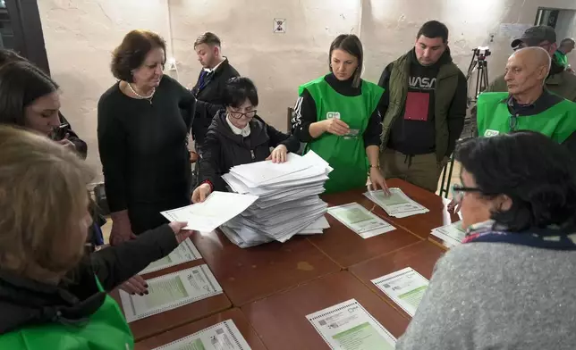 Members of an election commission count ballots at a polling station after the parliamentary election in Tbilisi, Georgia, Saturday, Oct. 26, 2024. (AP Photo/Kostya Manenkov)