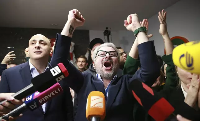 From left, Nika Melia and Nika Gvaramia, leaders of Coalition for Changes, react while talking to journalists at coalition's headquarters after polls closing at the parliamentary election in Tbilisi, Georgia, Saturday, Oct. 26, 2024. (AP Photo/Zurab Tsertsvadze)