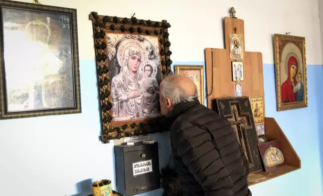 A man kisses an Orthodox ikon at a polling station during the parliamentary election in Tbilisi, Georgia, Saturday, Oct. 26, 2024. (AP Photo/Shakh Aivazov)