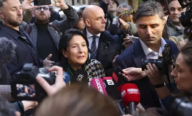 In this photo released by Georgian Presidential Press Office, Georgian President Salome Zourabichvili, center, speaks to the media after voting at a polling station during the parliamentary election in Tbilisi, Georgia, Saturday, Oct. 26, 2024. (Georgian Presidential Press Office via AP)