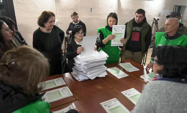 Members of an election commission count ballots at a polling station after the parliamentary election in Tbilisi, Georgia, Saturday, Oct. 26, 2024. (AP Photo/Kostya Manenkov)