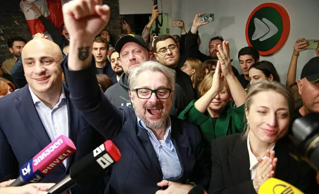 From left, Nika Melia, Nika Gvaramia, leaders of Coalition for Changes, and Nana Malashkhia, who leads the Coalition for Change parliament list, react while talking to journalists at coalition's headquarters after polls closing at the parliamentary election in Tbilisi, Georgia, Saturday, Oct. 26, 2024. (AP Photo/Zurab Tsertsvadze)