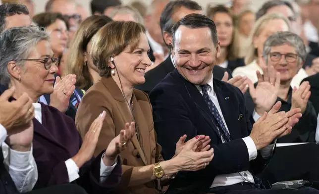 American journalist and historian Anne Applebaum claps hands with her husband Poland's Foreign Minister Radosław Sikorski during the Peace Prize of the German Book Trade ceremony for Anne Applebaum at the St. Paul's Church in Frankfurt, Germany, Sunday, Oct. 20, 2024.(AP Photo/Martin Meissner, Pool)