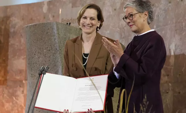 American journalist and historian Anne Applebaum, left, is awarded with the Peace Prize of the German Book Trade by Karin Schmidt-Friderichs, head of the German Publishers and Booksellers Association during a ceremony at the St. Paul's Church in Frankfurt, Germany, Sunday, Oct. 20, 2024.(AP Photo/Martin Meissner, Pool)