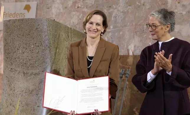 American journalist and historian Anne Applebaum, left, is awarded with the Peace Prize of the German Book Trade by Karin Schmidt-Friderichs, head of the German Publishers and Booksellers Association during a ceremony at the St. Paul's Church in Frankfurt, Germany, Sunday, Oct. 20, 2024.(AP Photo/Martin Meissner, Pool)