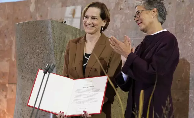 American journalist and historian Anne Applebaum, left, is awarded with the Peace Prize of the German Book Trade by Karin Schmidt-Friderichs, head of the German Publishers and Booksellers Association during a ceremony at the St. Paul's Church in Frankfurt, Germany, Sunday, Oct. 20, 2024.(AP Photo/Martin Meissner, Pool)