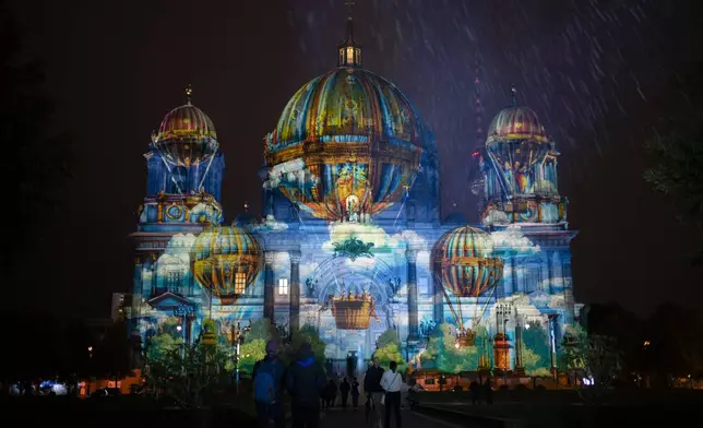 Berlin Cathedral is illuminated during a rehearsal for the upcoming Festival of Lights in Berlin, Germany, Wednesday, Oct. 2, 2024. (AP Photo/Markus Schreiber)