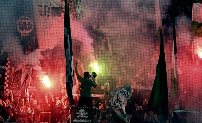 Fans of VfL Wolfsburg set off pyrotechnics during a second-round German Cup soccer match against Borussia Dortmund, Tuesday, Oct. 29, 2024, in Wolfsburg, Germany. (Swen Pförtner/dpa via AP)