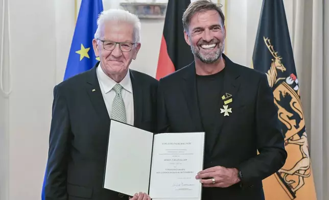 Soccer coach Juergen Klopp, right, receives the Order of Merit of the German State of Baden-Wuerttemberg in Stuttgart, Germany, Tuesday, Oct. 8, 2024, from Governor Winfried Kretschmann, left, for his wide-ranging social commitment outside of sport. (Bernd Weissbrod/dpa via AP)