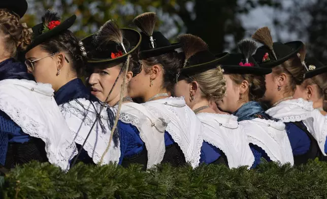 Women in traditional costumes of the region take part at the traditional Leonhardi pilgrimage in Warngau near Munich, Germany, Sunday, Oct. 27, 2024. The annual pilgrimage honors St. Leonhard, patron saint of the highland farmers for horses and livestock. (AP Photo/Matthias Schrader)