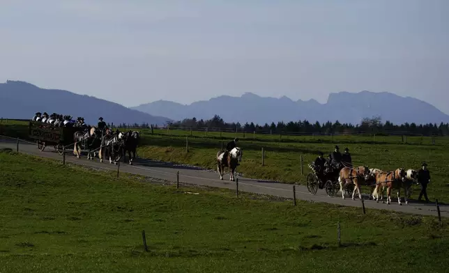 People in traditional costumes of the region take part at the traditional Leonhardi pilgrimage in Warngau near Munich, Germany, Sunday, Oct. 27, 2024. The annual pilgrimage honors St. Leonhard, patron saint of the highland farmers for horses and livestock. (AP Photo/Matthias Schrader)