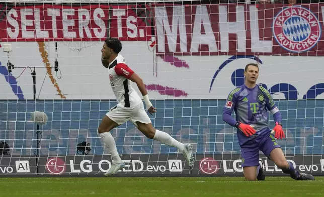 Frankfurt's Omar Marmoush, centre, celebrates after scoring his side's first goal past Bayern's goalkeeper Manuel Neuer during the German Bundesliga soccer match between Eintracht Frankfurt and Bayern Munich in Frankfurt, Germany, Sunday, Oct. 6, 2024. (AP Photo/Michael Probst)