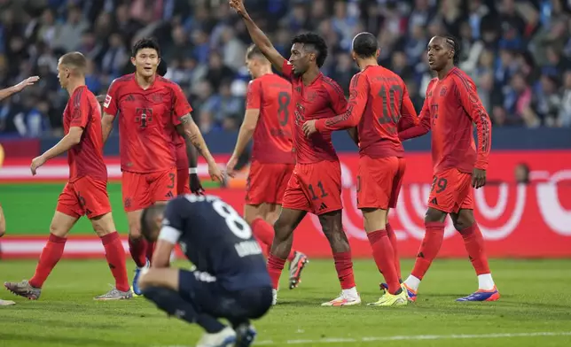 Bayern's Kingsley Coman raises his hand after he scored during the German Bundesliga soccer match between VfL Bochum and Bayern Munich in Bochum, Germany, Sunday, Oct. 27, 2024. (AP Photo/Martin Meissner)