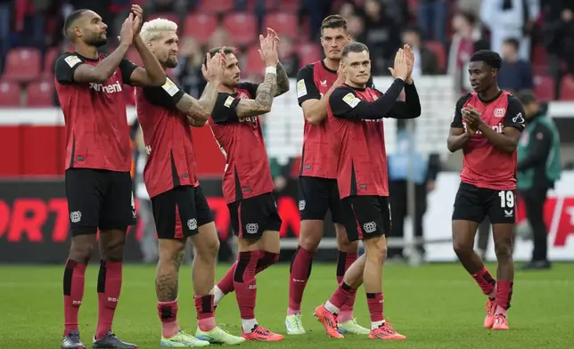 Leverkusen players celebrate after the German Bundesliga soccer match between Bayer Leverkusen and Eintracht Frankfurt at the BayArena in Leverkusen, Germany, Saturday, Oct. 19, 2024. (AP Photo/Martin Meissner)