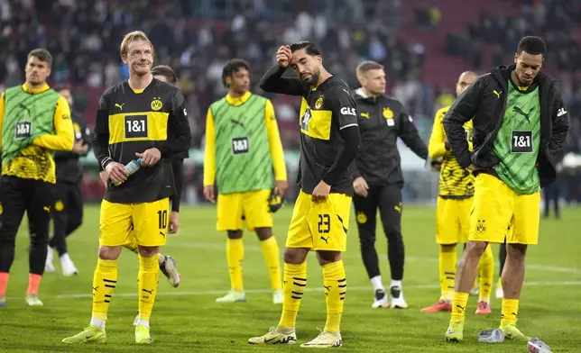 Borussia Dortmund players stand on the pitch in dejection at the end of the Bundesliga soccer match between FC Augsburg and Borussia Dortmund at WWK-Arena, Augsburg, Germany, Saturday, Oct. 26, 2024. (AP Photo/Matthias Schrader)