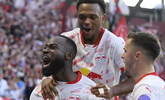 From left, Leipzig's Lutsharel Geertruida celebrates with Lois Openda and Christoph Baumgartner after scoring during the German Bundesliga soccer match between RB Leipzig and SC Freiburg at the Red Bull Arena in Leipzig, Germany, Saturday, Oct. 26, 2024. (Hendrik Schmidt/dpa via AP)