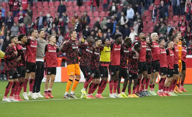 Leverkusen players celebrate after the German Bundesliga soccer match between Bayer Leverkusen and Eintracht Frankfurt at the BayArena in Leverkusen, Germany, Saturday, Oct. 19, 2024. (AP Photo/Martin Meissner)