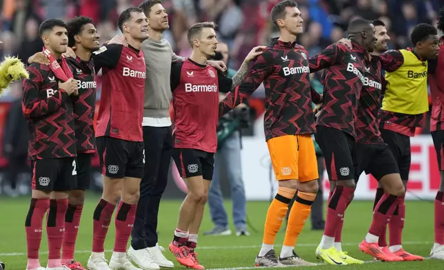 Leverkusen players celebrate after the German Bundesliga soccer match between Bayer Leverkusen and Eintracht Frankfurt at the BayArena in Leverkusen, Germany, Saturday, Oct. 19, 2024. (AP Photo/Martin Meissner)