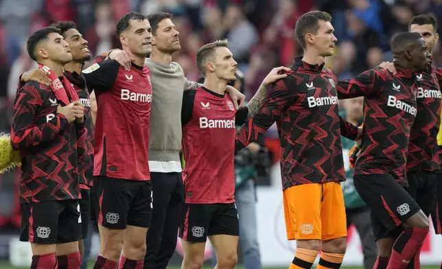 Leverkusen players celebrate after the German Bundesliga soccer match between Bayer Leverkusen and Eintracht Frankfurt at the BayArena in Leverkusen, Germany, Saturday, Oct. 19, 2024. (AP Photo/Martin Meissner)