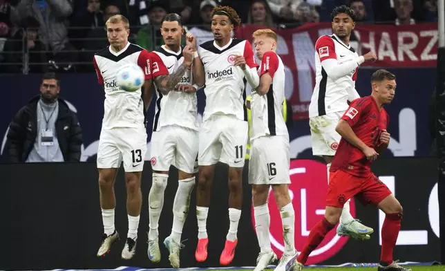 From left: Frankfurt's Rasmus Kristensen, Robin Koch, Hugo Ekitike, Hugo Larsson and Omar Marmoush jump to block a free kick during the German Bundesliga soccer match between Eintracht Frankfurt and Bayern Munich in Frankfurt, Germany, Sunday, Oct. 6, 2024. (AP Photo/Michael Probst)