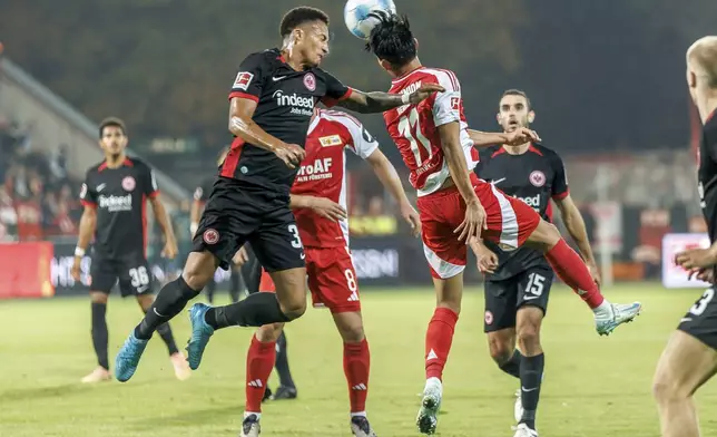 Tuta, left, of Eintracht Frankfurt fights for the ball with Berlin's Wooyeong Jeong during the German Bundesliga soccer match between Eintracht Frankfurt and Union Berlin, in Berlin, Sunday, Oct. 27, 2024. (Andreas Gora/dpa via AP)