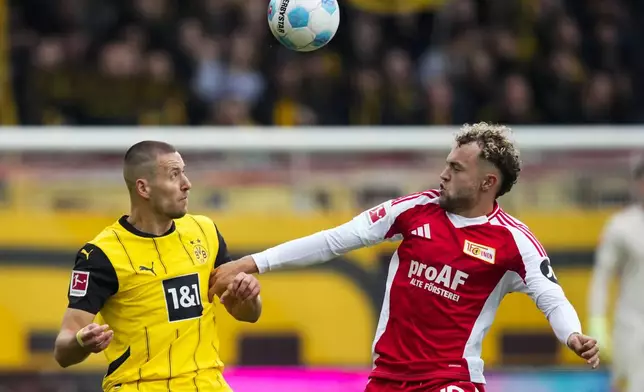 Dortmund's Waldemar Anton, left, and Union's Benedict Hollerbach fight for the ball during the Bundesliga soccer match between Union Berlin and Borussia Dortmund in Berlin, Germany, on Saturday, Oct. 5, 2024.(AP Photo/Ebrahim Noroozi)