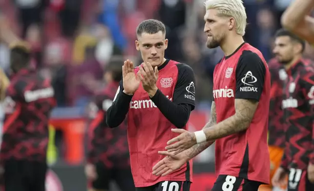 Leverkusen's Florian Wirtz applauds after the German Bundesliga soccer match between Bayer Leverkusen and Eintracht Frankfurt at the BayArena in Leverkusen, Germany, Saturday, Oct. 19, 2024. (AP Photo/Martin Meissner)