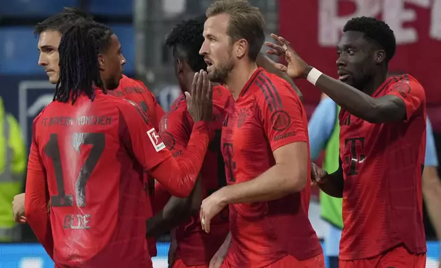 Bayern players celebrate Harry Kane after he scored a goal during the German Bundesliga soccer match between VfL Bochum and Bayern Munich in Bochum, Germany, Sunday, Oct. 27, 2024. (AP Photo/Martin Meissner)