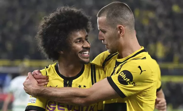 Dortmund's Karim Adeyemi, left, celebrates with Waldemar Anton, after scoring his side's third goal during the Champions League opening phase soccer match between Borussia Dortmund and Celtic FC in Dortmund, Germany, Tuesday, Oct. 1, 2024. (Bernd Thissen/dpa via AP)