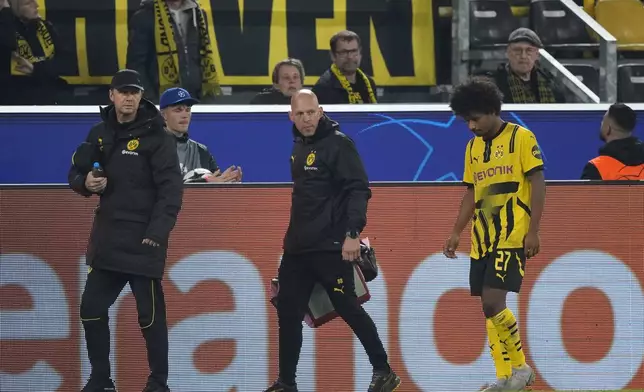 Dortmund's Karim Adeyemi, right, leaves the pitch after an injuring during the Champions League opening phase soccer match between Borussia Dortmund and Celtic FC at the BVB Stadion in Dortmund, Germany, Tuesday, Oct. 1, 2024. (AP Photo/Martin Meissner)