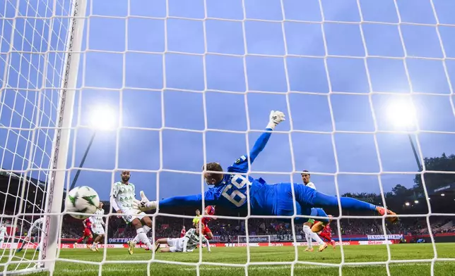 Heidenheim's Adrian Beck scores the opening goal past Ljubljana's goalkeeper Matevz Vidovsek during the Europa League soccer match between TSG 1899 Hoffenheim and Dynamo Kiev at PreZero Arena in Sinsheim, Germany, Thursday, Oct. 3, 2024. (Uwe Anspach/dpa via AP)