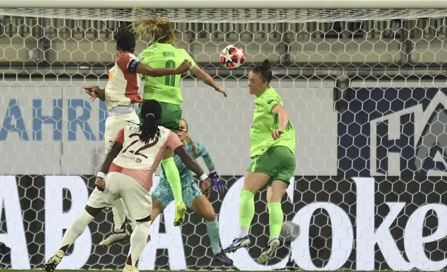 Lyon's Wendie Renard, top let, heads the ball to score their side's first goal of the game during the Women's Champions League group stage soccer match between VfL Wolfsburg and Olympique Lyon, at the AOK Stadion in Wolfsburg, Germany, Thursday Oct. 17, 2024. (Swen Pförtner/dpa via AP)