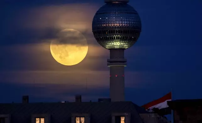 The full Hunters Supermoon rises next to the television tower in Berlin, Germany, Thursday, Oct. 17, 2024. (AP Photo/Michael Probst)