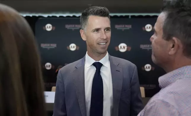 San Francisco Giants president of baseball operations Buster Posey speaks with people after a news conference in San Francisco, Tuesday, Oct. 1, 2024. (AP Photo/Jeff Chiu)