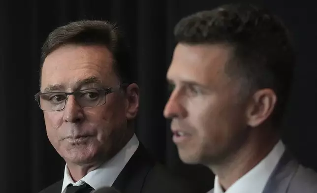 San Francisco Giants manager Bob Melvin, left, listens as president of baseball operations Buster Posey speaks during a news conference in San Francisco, Tuesday, Oct. 1, 2024. (AP Photo/Jeff Chiu)