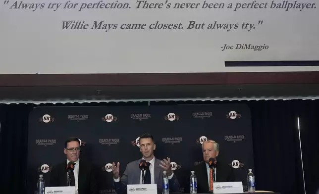 San Francisco Giants new president of baseball operations Buster Posey, center, speaks between manager Bob Melvin, left, and chairman Greg Johnson during a news conference in San Francisco, Tuesday, Oct. 1, 2024. (AP Photo/Jeff Chiu)