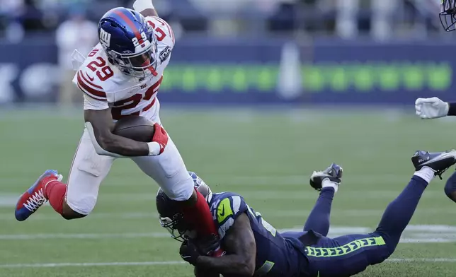 New York Giants running back Tyrone Tracy Jr. (29) is tackled by Seattle Seahawks cornerback Tre Brown (22) during the second half of an NFL football game, Sunday, Oct. 6, 2024, in Seattle. (AP Photo/John Froschauer)