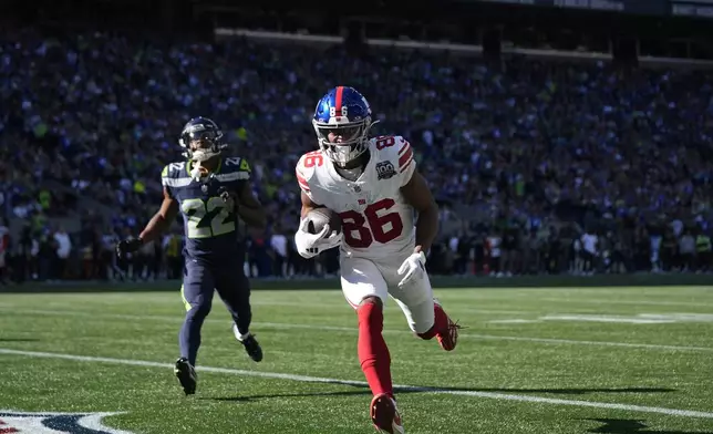 New York Giants wide receiver Darius Slayton (86) scores a 30-yard touchdown ahead of Seattle Seahawks cornerback Tre Brown (22) during the second half of an NFL football game, Sunday, Oct. 6, 2024, in Seattle. (AP Photo/Lindsey Wasson)