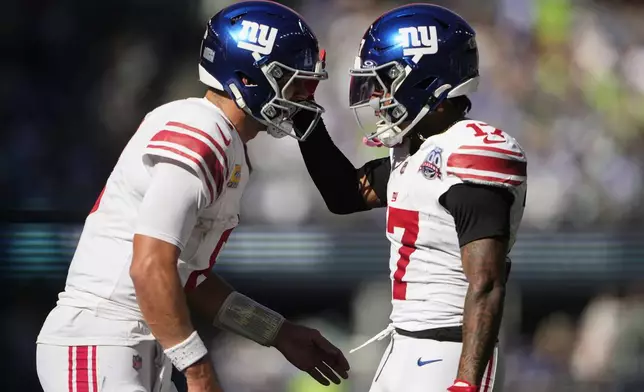 New York Giants quarterback Daniel Jones (8), left, celebrates with teammate wide receiver Wan'Dale Robinson (17) after Robinson caught a 7-yard touchdown pass during the first half of an NFL football game against the Seattle Seahawks, Sunday, Oct. 6, 2024, in Seattle. (AP Photo/Lindsey Wasson)