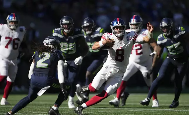 New York Giants quarterback Daniel Jones (8) runs with the football during the first half of an NFL football game against the Seattle Seahawks, Sunday, Oct. 6, 2024, in Seattle. (AP Photo/Lindsey Wasson)